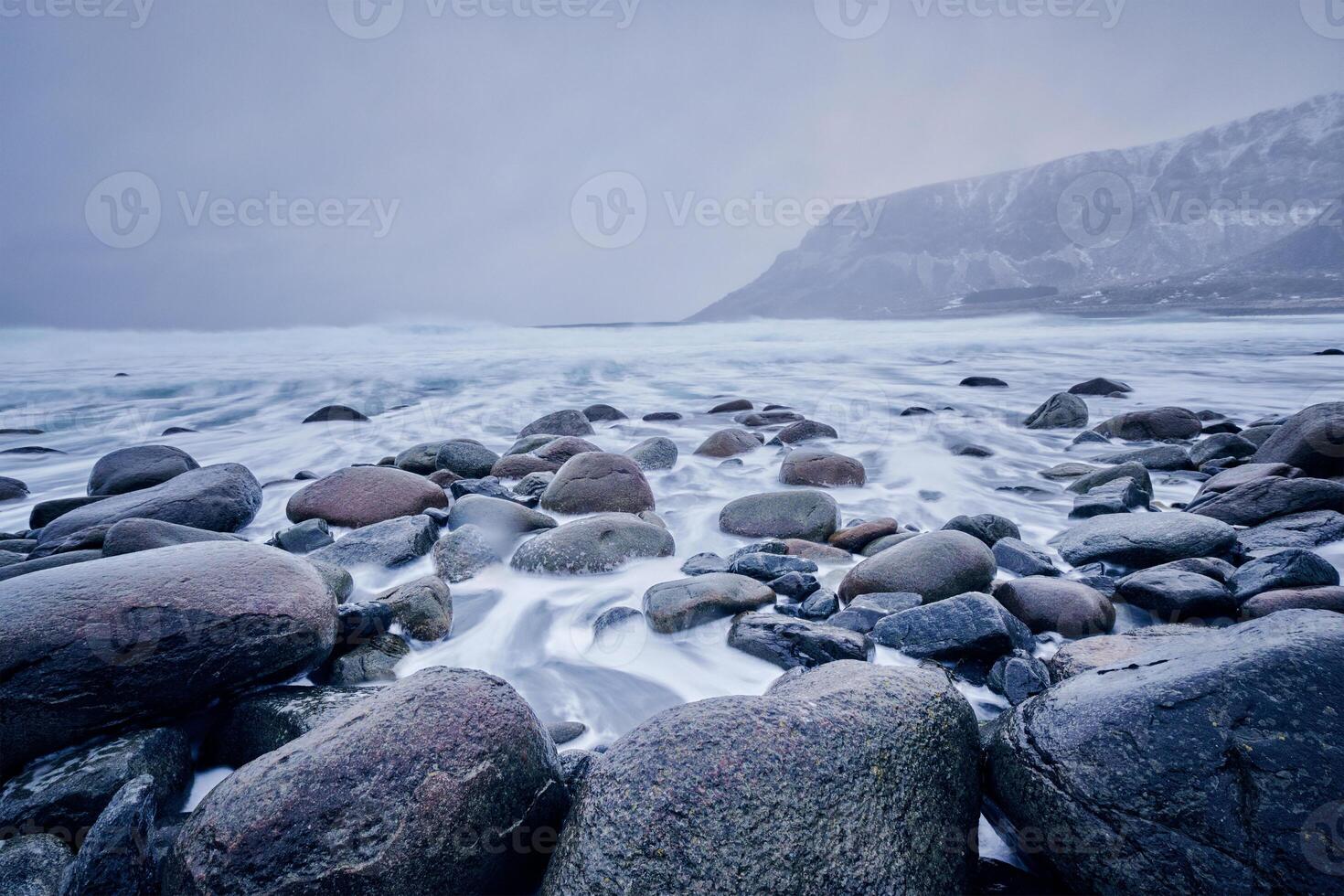 Waves of Norwegian sea surging on stone rocks. Long exposure photo