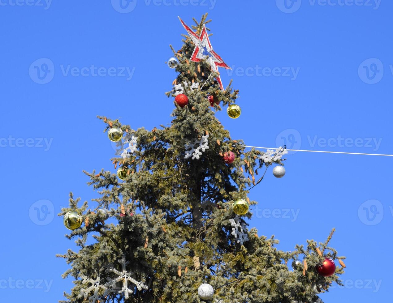 decoraciones nuevo año árbol. oropel y juguetes, pelotas y otro decoraciones en el Navidad Navidad árbol en pie en el abierto aire. foto