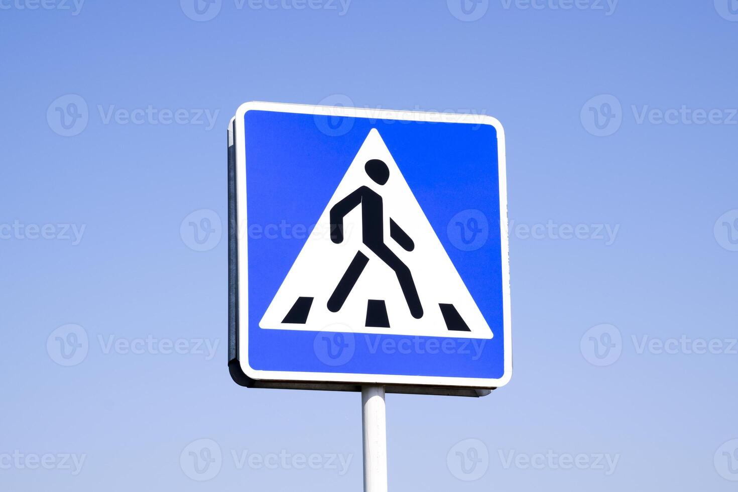 A pedestrian crossing sign. Sign on a blue sky background. photo