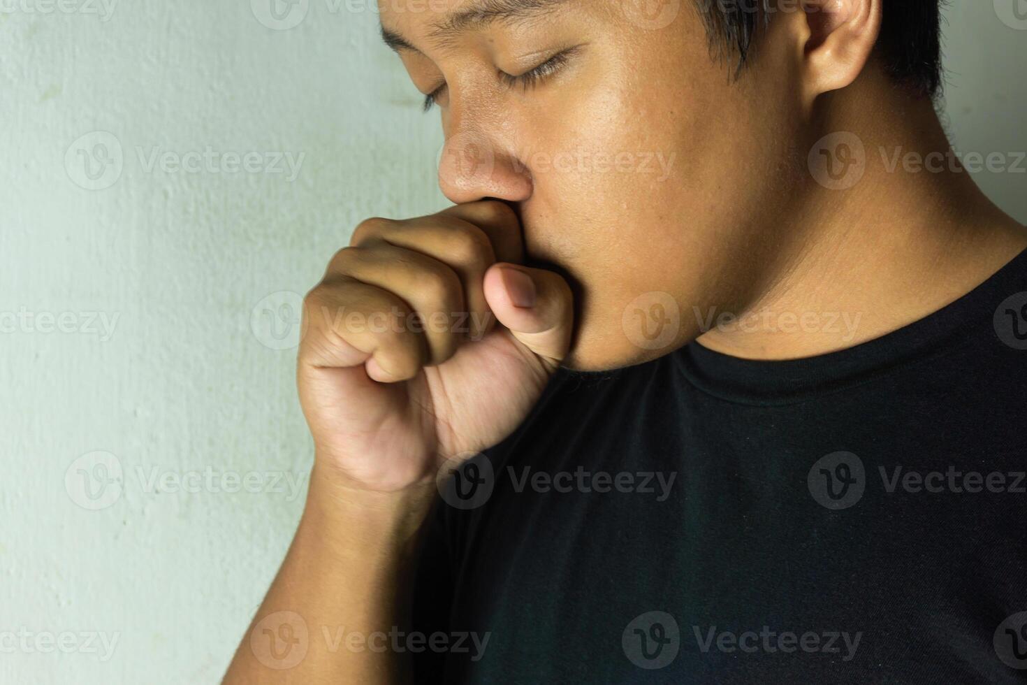 man feeling ill with a sore throat. Cold symptoms. Close up of asian man coughing. photo