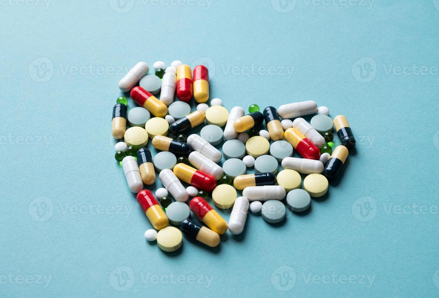 heart shape made of different pills on blue background photo
