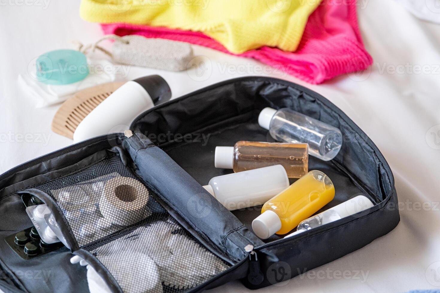 Travel cosmetics kit on bed photo