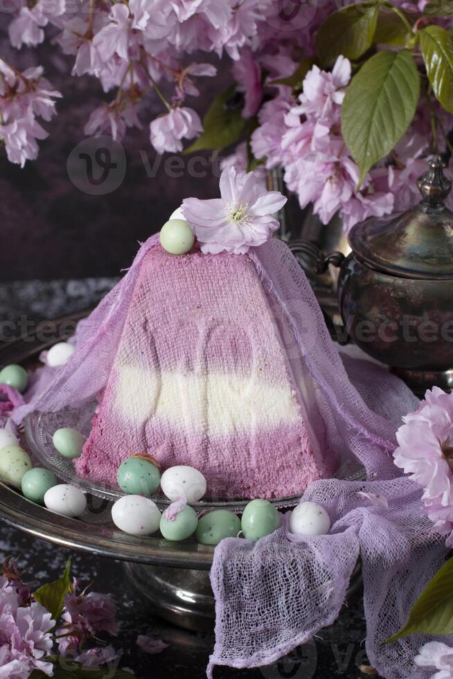 dulce Cuajada ortodoxo Pascua de Resurrección en el antecedentes de púrpura sakura, tradicional comida foto