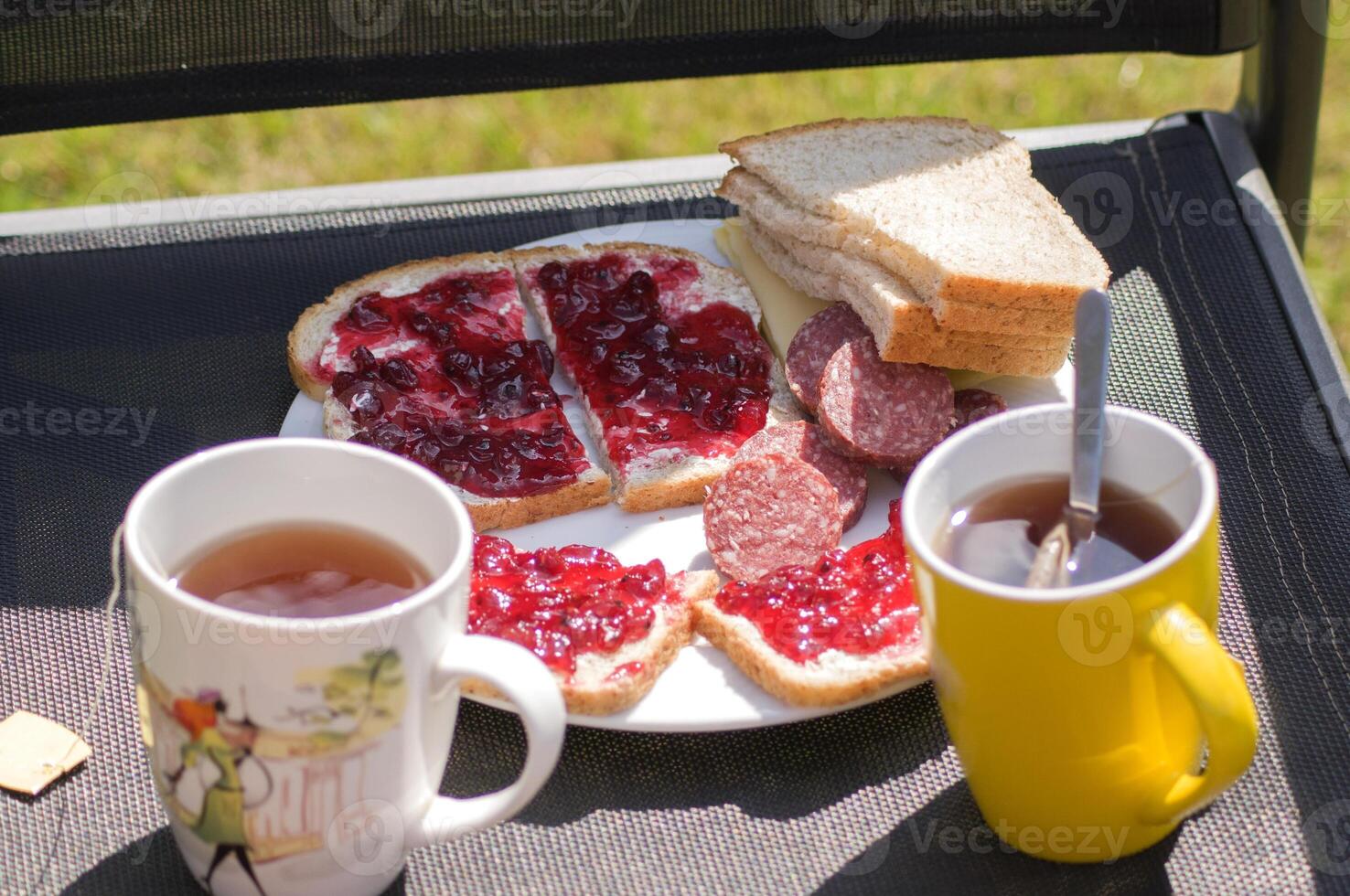 breakfast in the garden on a chair two sandwiches with sausage and butter jam photo