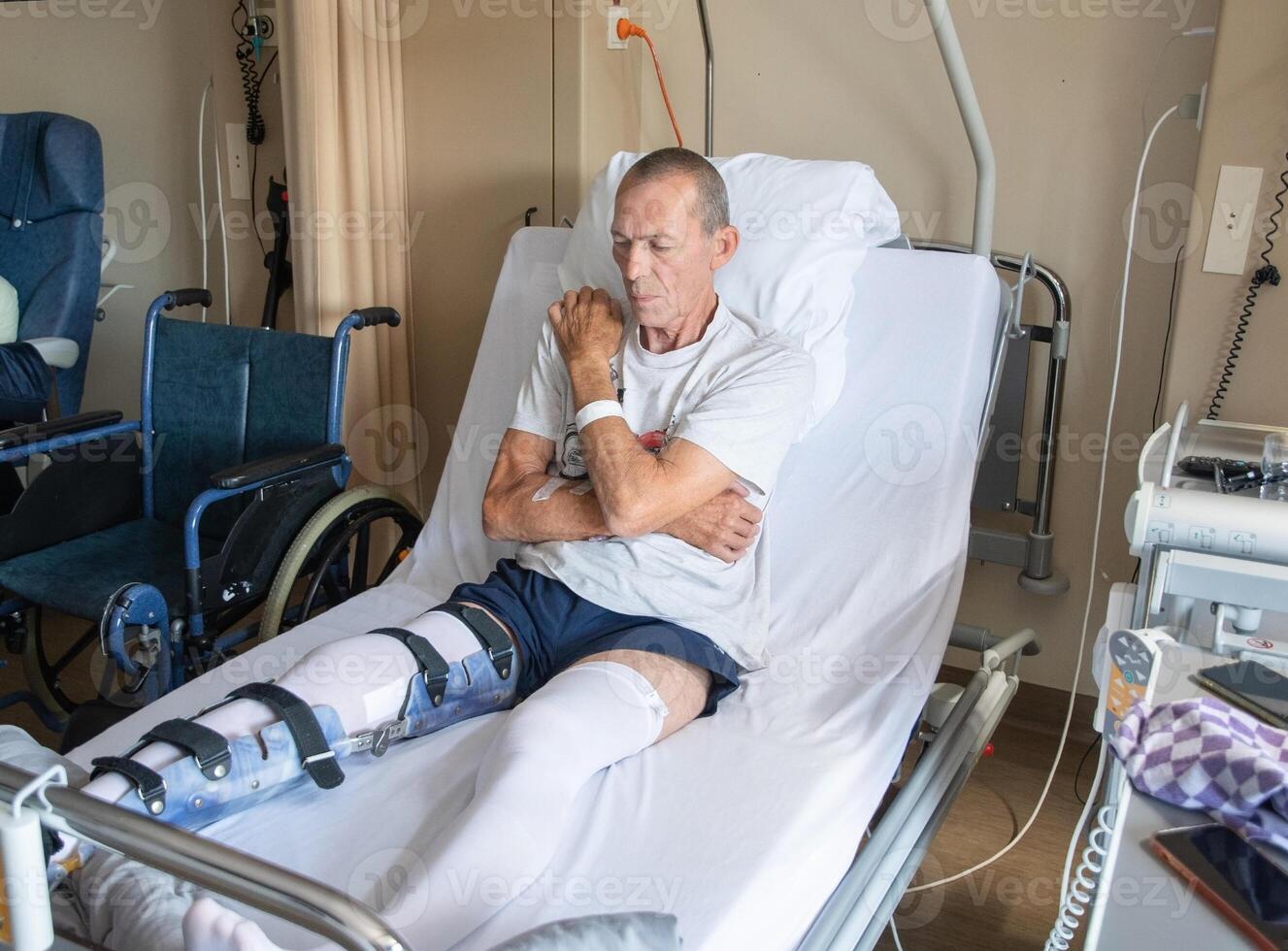 a man with a broken leg in an orthosis on a bed in a clinic after an accident and a fracture of the femur photo