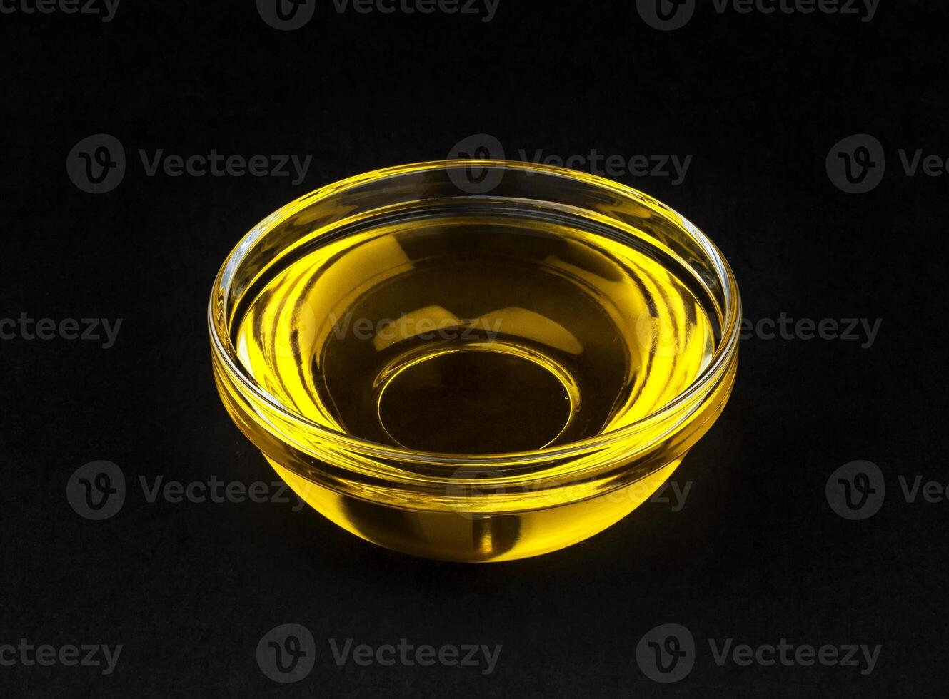 Vegetable oil in bowl on black background photo