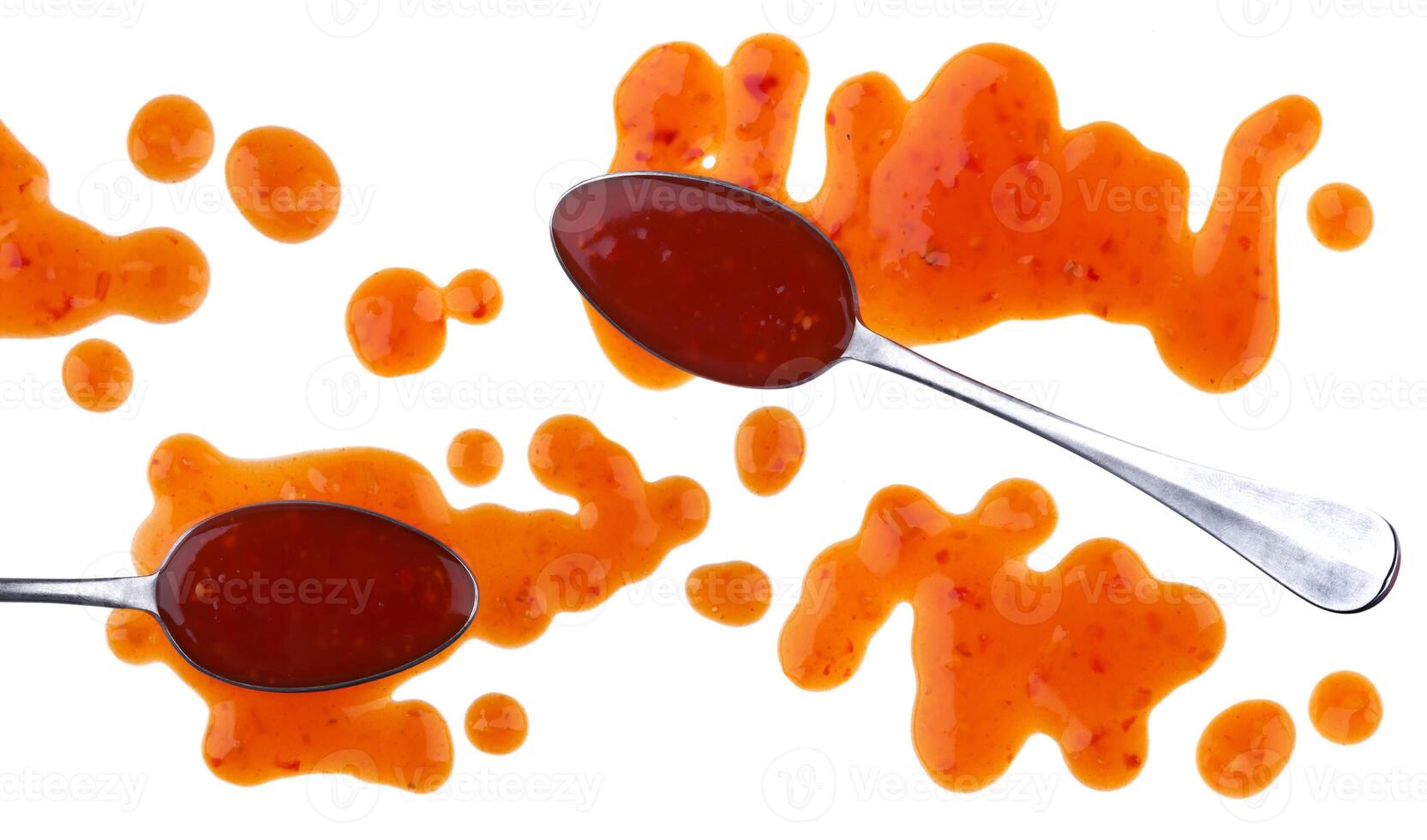 Splach of sweet and sour sauce with spoon isolated on white background. Top view photo