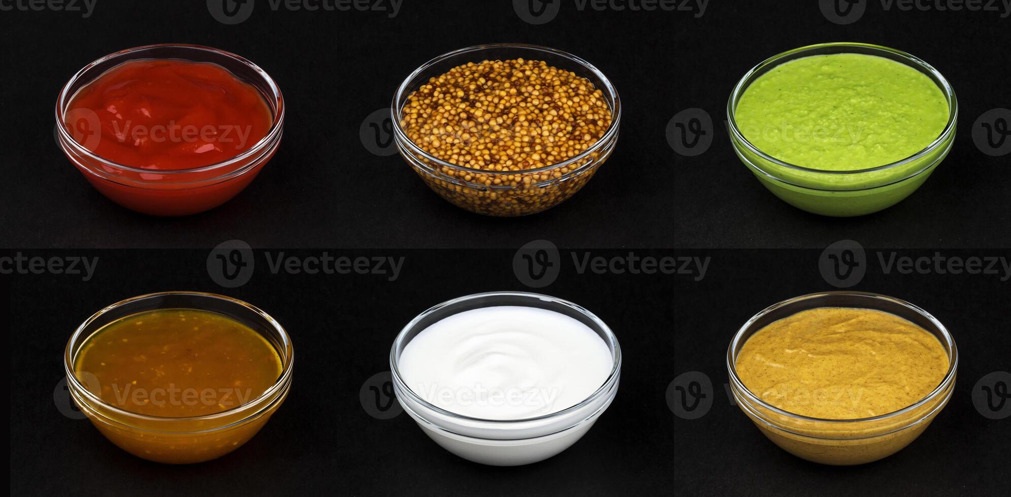 Different sauces isolated on black background photo