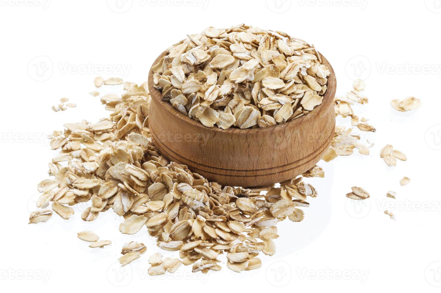 Oat flakes in wooden bowl isolated on white background photo