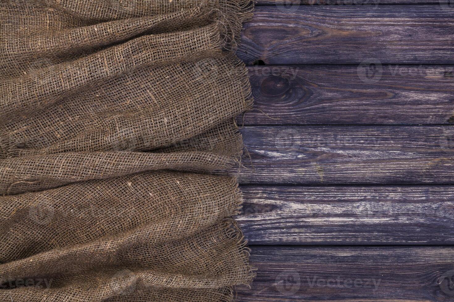 Burlap on dark wooden background, top view photo