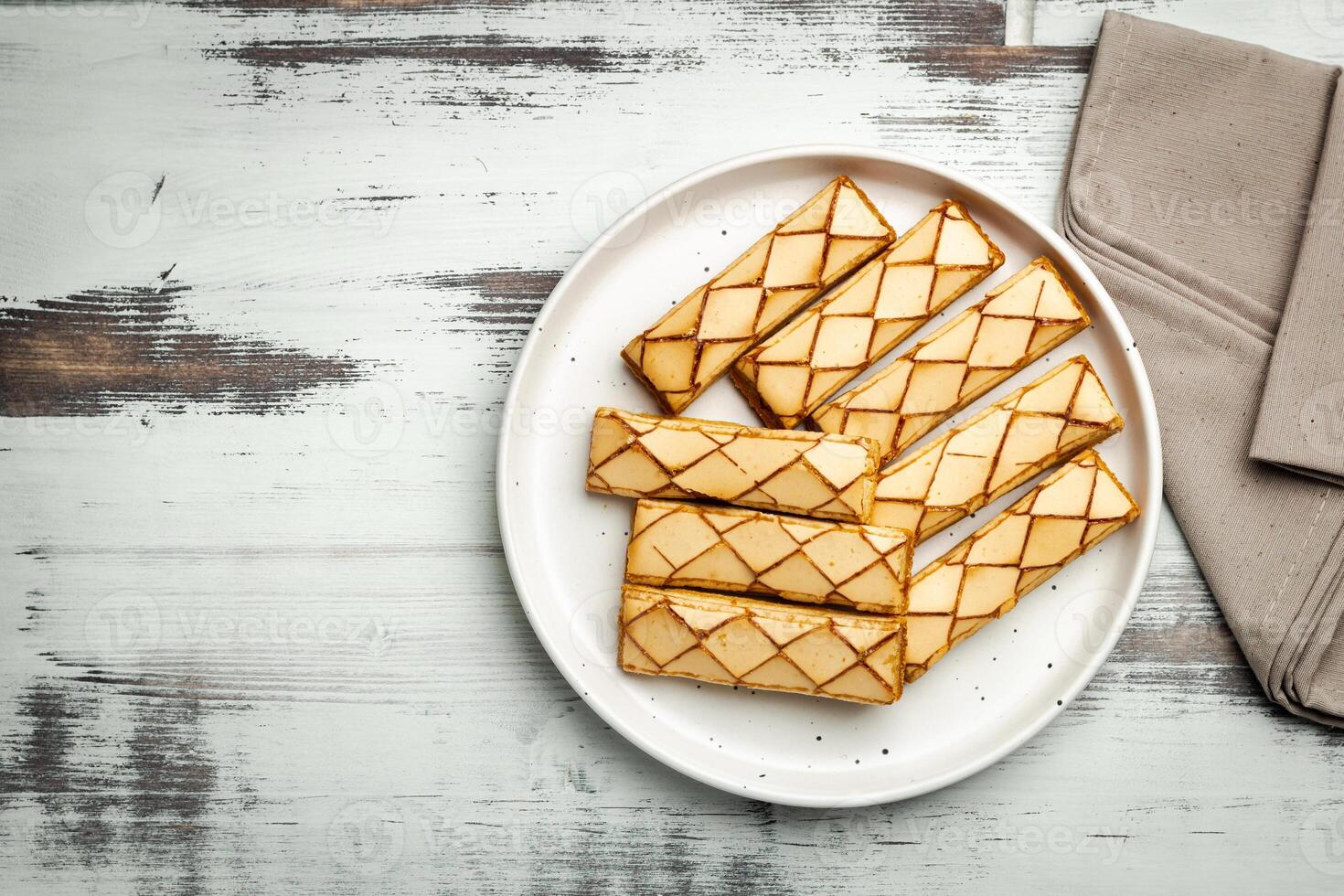 Sfogliatine, an Italian puff pastry with glaze on a plate on white background, top view photo