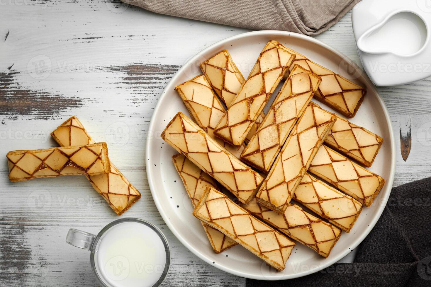 Sfogliatine, an Italian puff pastry with glaze on a plate on white background, top view photo