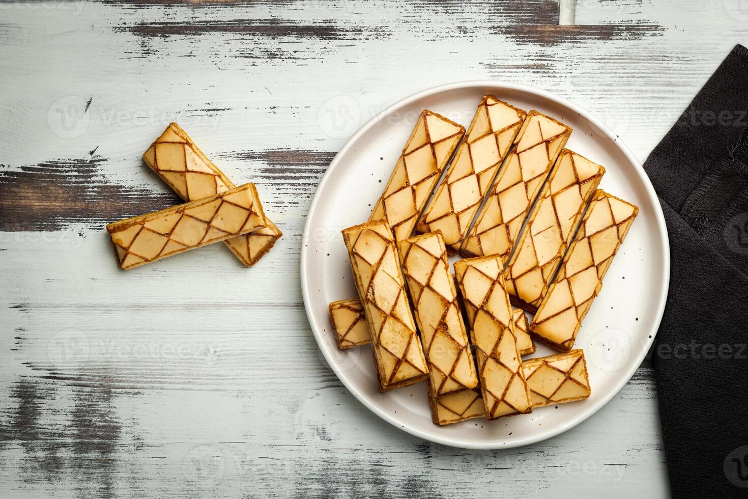 Sfogliatine, an Italian puff pastry with glaze on a plate on white background, top view photo