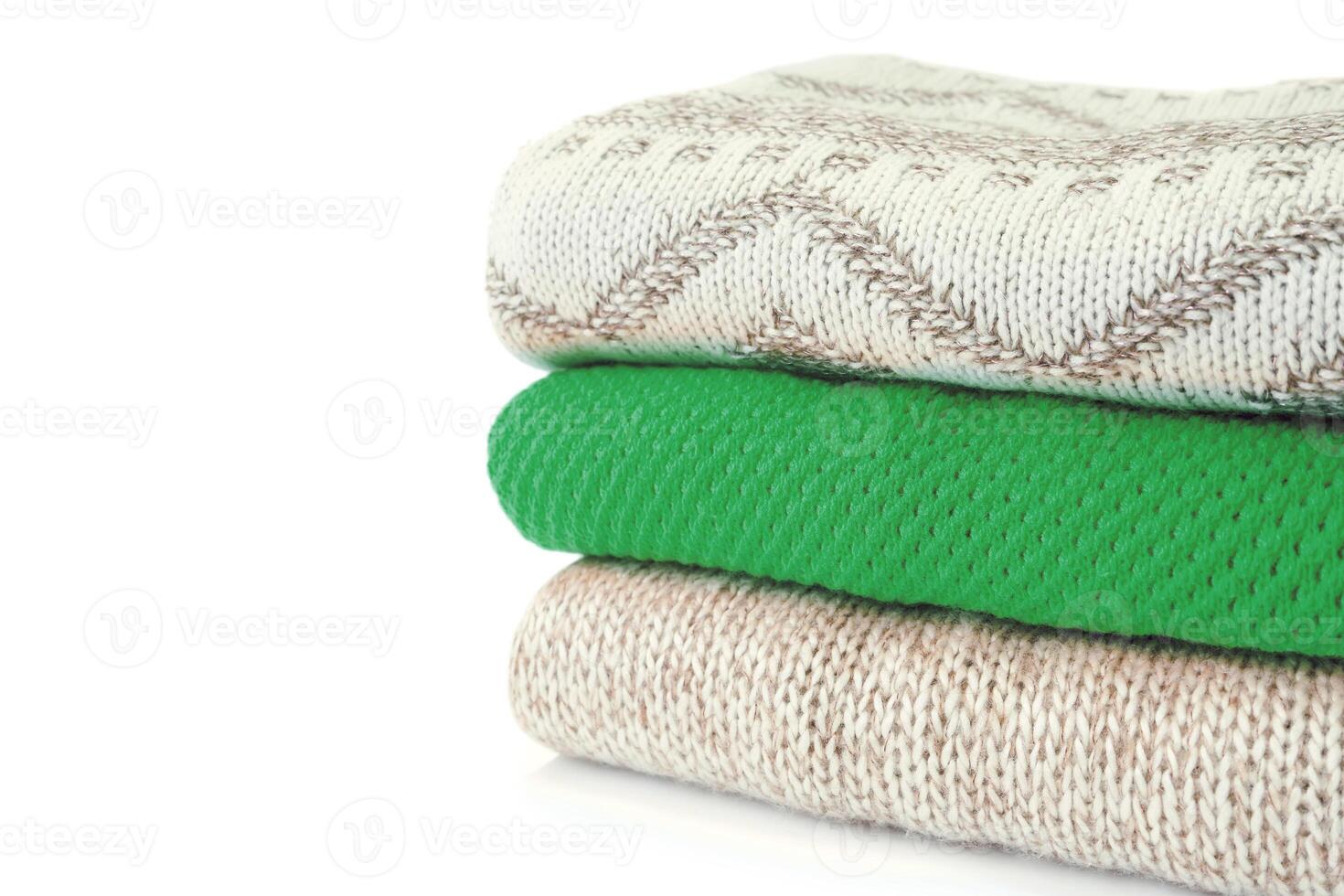 Stack of various sweaters isolated on white background photo