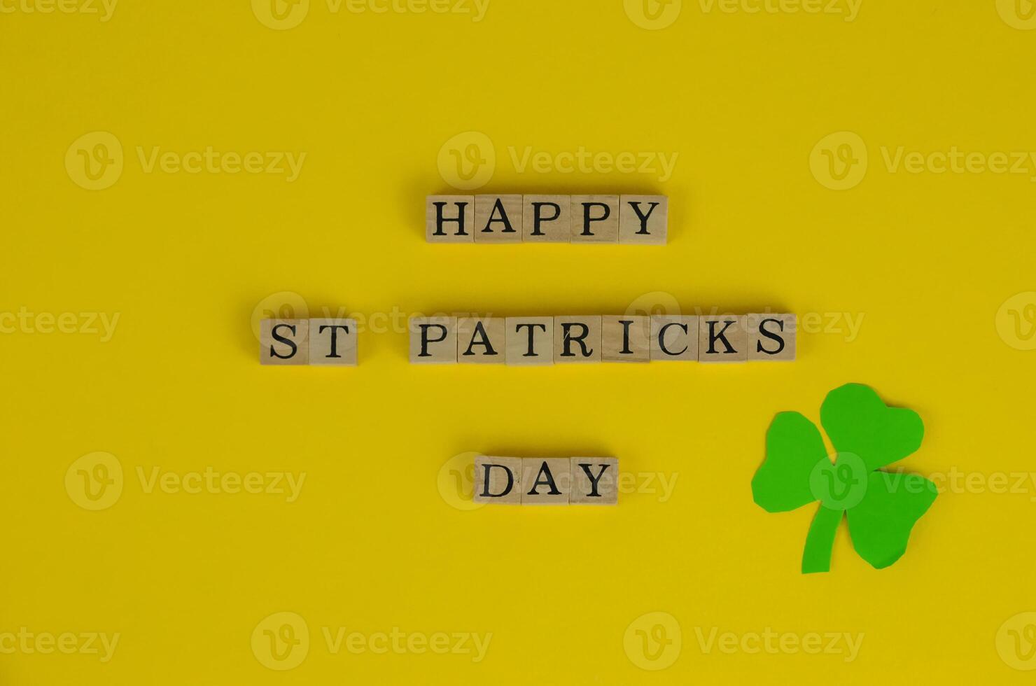 Happy St. Patrick's Day Words on Yellow Background With Three-Leaf Clover Leaf photo