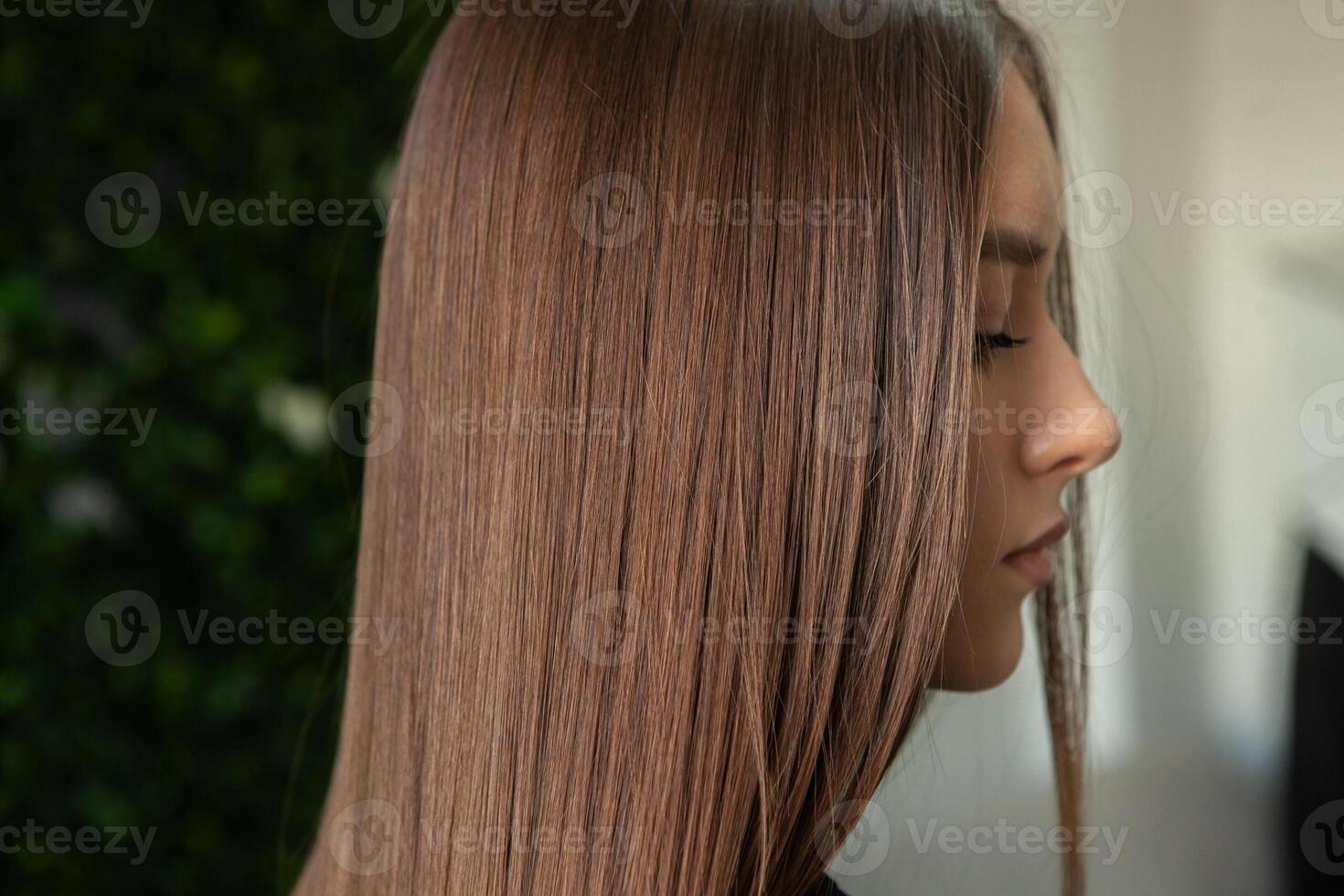 foto de un europeo niña con largo y hermosa morena pelo a el belleza salón. brillante y sano cabello.