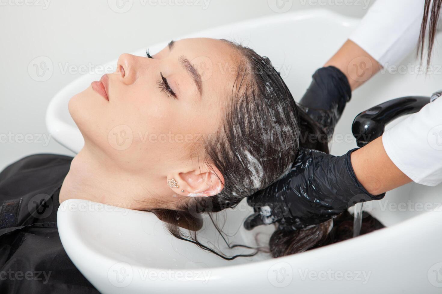 photo of a European girl with long and beautiful brunette hair at the beauty salon. Shiny and healthy hair.