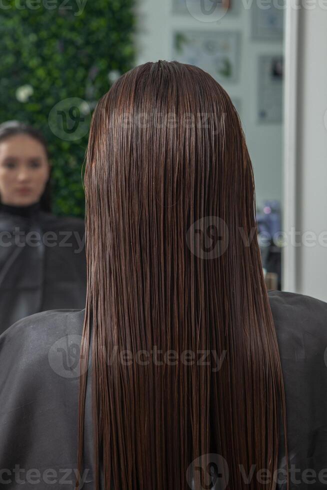 Portrait of a beautiful woman with long brown straight hair in a beauty salon. photo