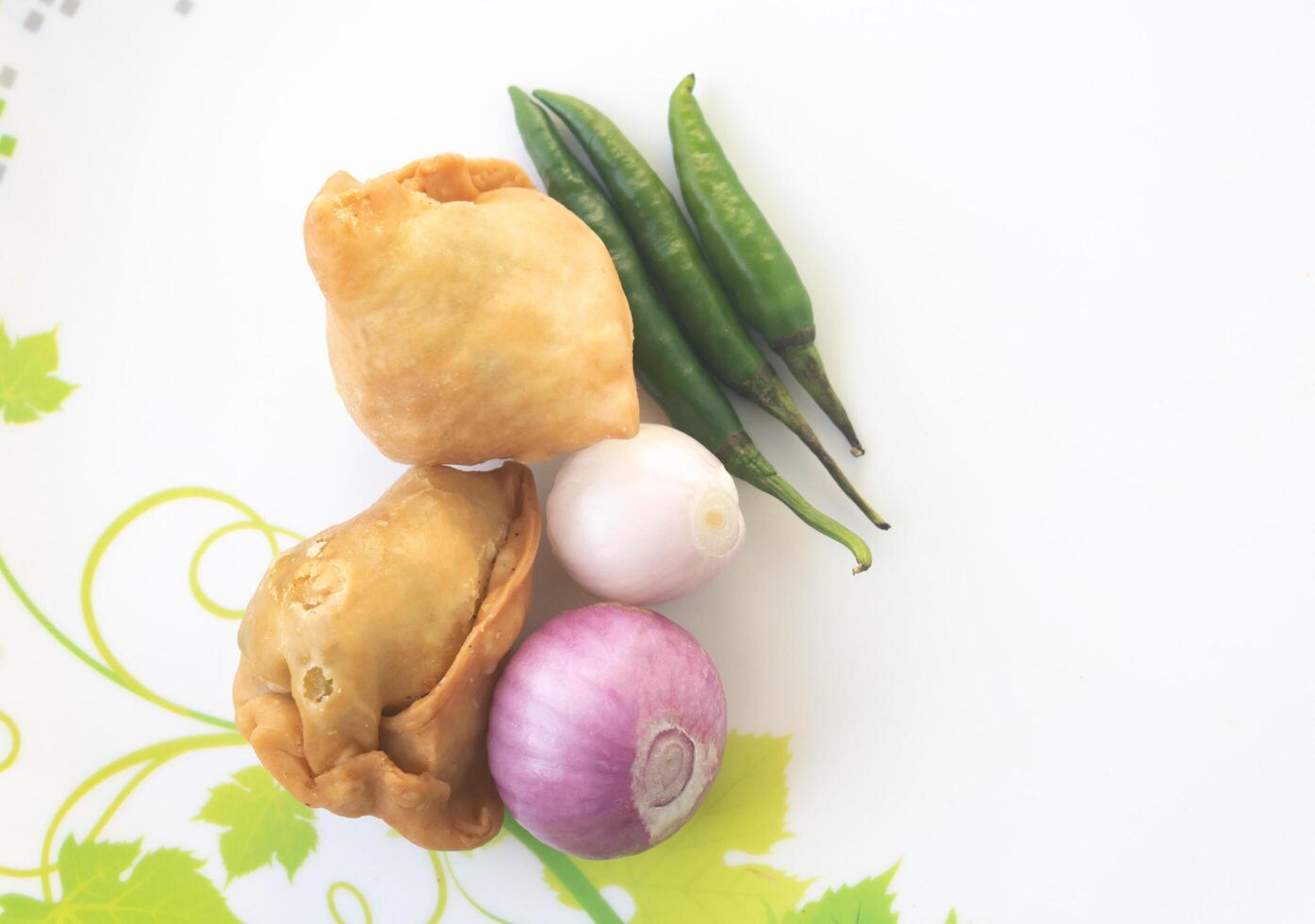 A samosa is a deep-fried pastry from South Asia that is filled with savory ingredients including peas, pork, fish, onions, or spicy potatoes. Also called Shingara. photo