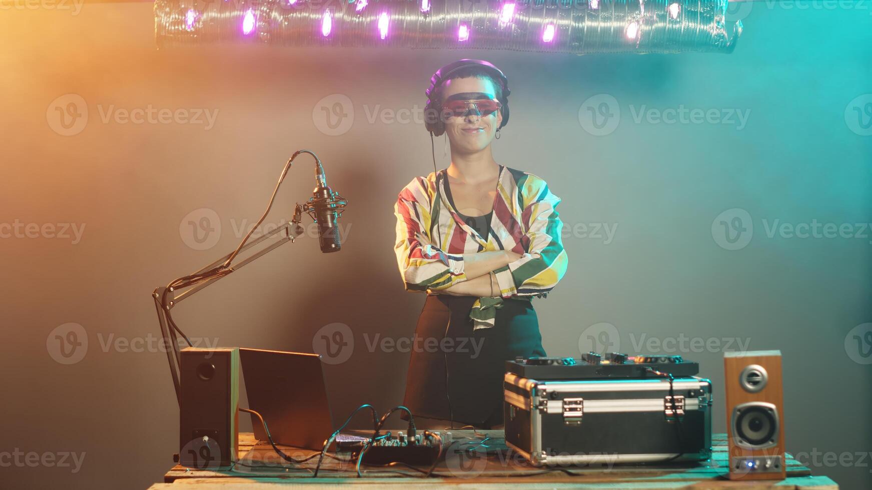 Woman dj mixing new sounds on turntables discs, using control key buttons to adjust bass and volume for techno music. Musician creating disco performance with mixer at club. Tripod shot. photo