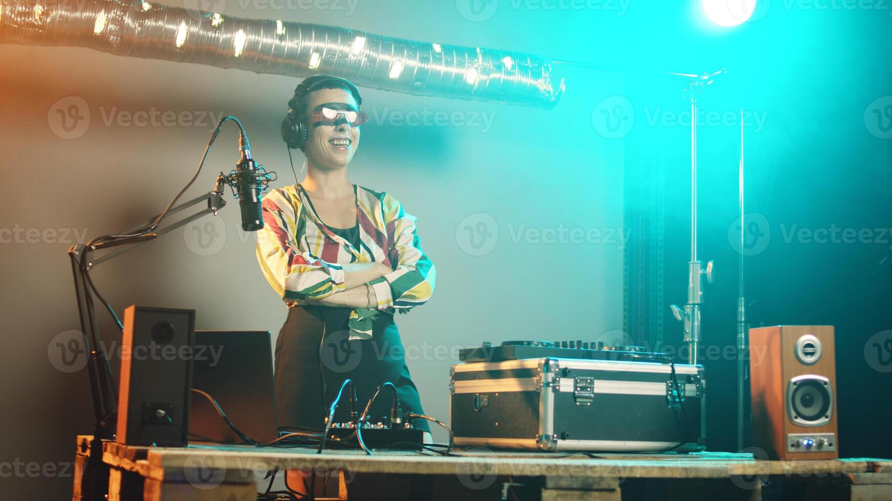 Woman disc jockey playing funky music on stereo turntables, mixing techno tunes with audio electronic instruments in studio. Cool artist working as mixer and using stereo electronics. Handheld shot. photo