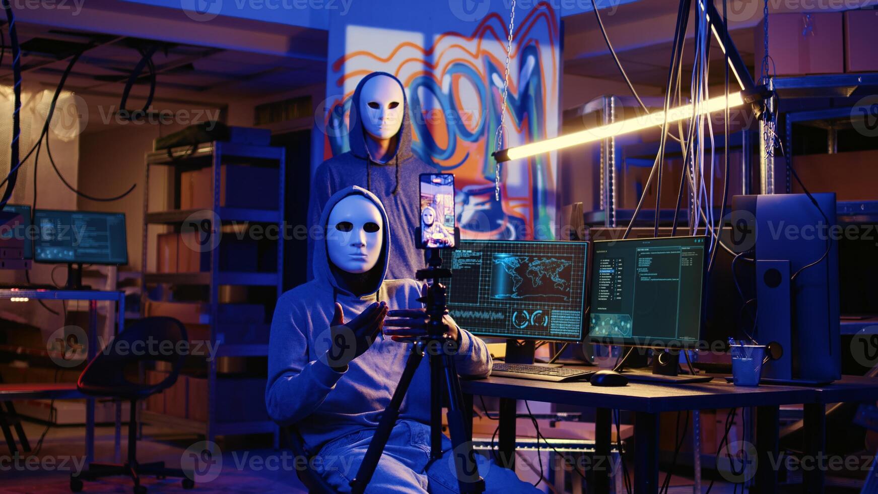 White hat hackers doing online activism, wearing anonymous masks and filming video threatening country government to reveal secret documents as revenge for putting citizens at risk photo