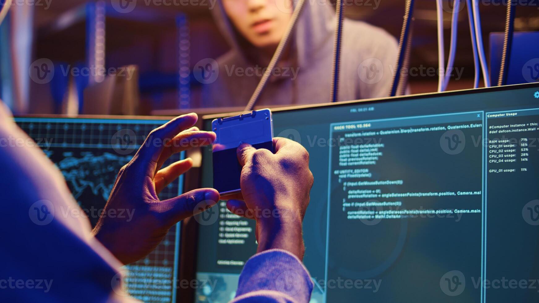 Close up shot on hacker holding SSD device with zero day exploit uploaded on it, able to go undetected by antivirus software installed on systems, showing it to fellow cracking group colleague photo