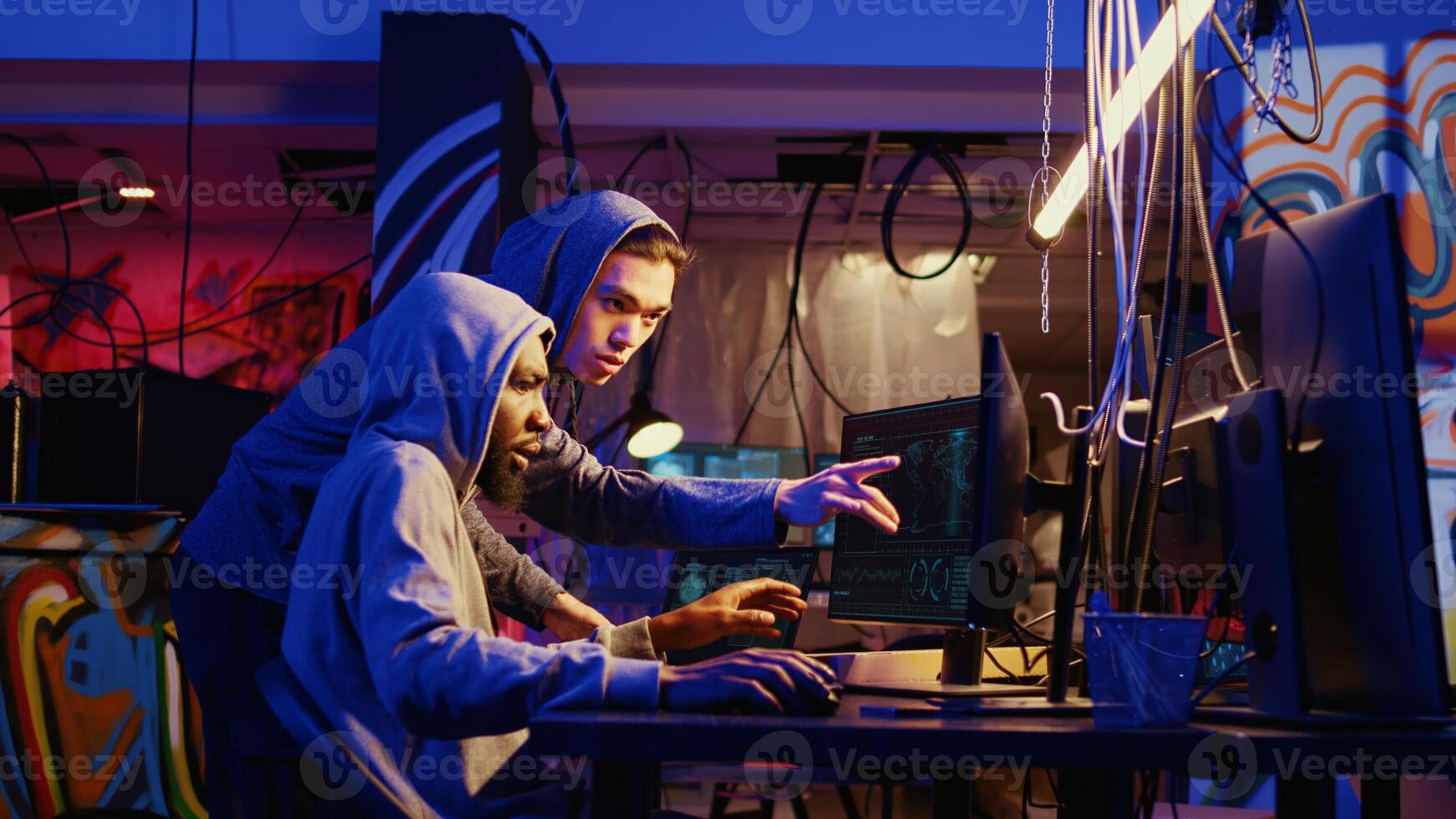 Hackers discussing how to best take advantage of security breach after gaining unauthorized access to system. Cybercriminals in secret hideout hacking network to steal government data photo