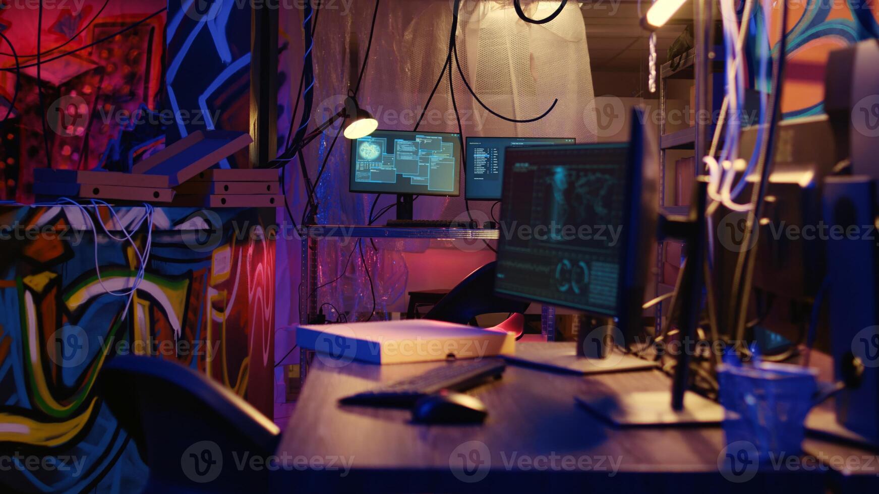 Dolly out shot of empty messy hackers base of operations with neon lights and graffiti drawings sprayed on walls. Ghetto hideout used by criminals to commit illegal activities using computers photo