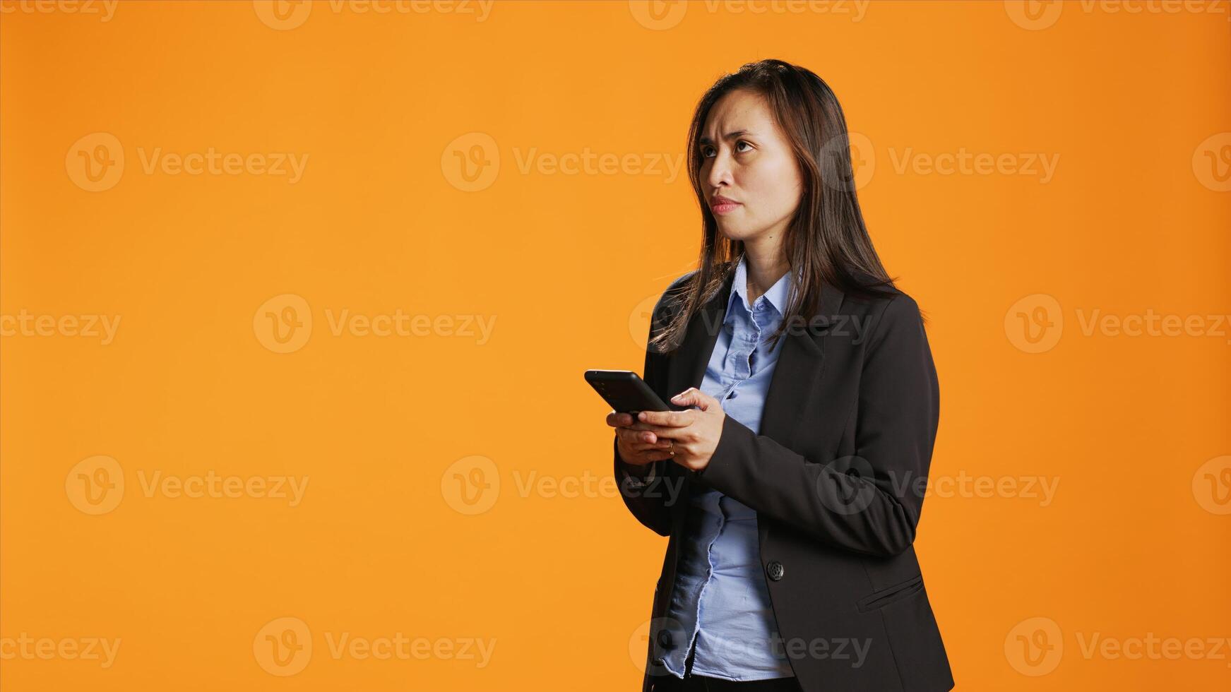 Asian business person messaging on smartphone app in studio, acting busy texting messages on social media network. Young adult using mobile device to send sms for remote communication. photo