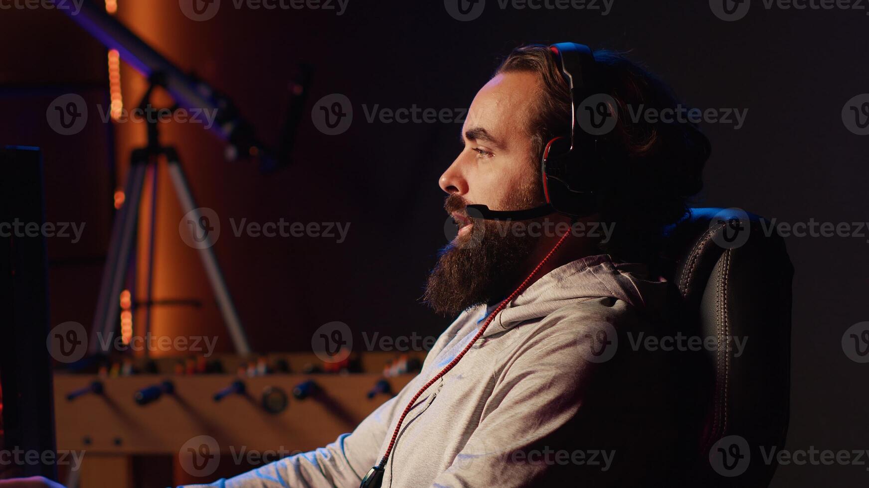 Man having fun with his friends playing videogames, chatting online using headphones microphone. Gamer using computer with powerful graphics to enjoy multiplayer experience with teammates photo