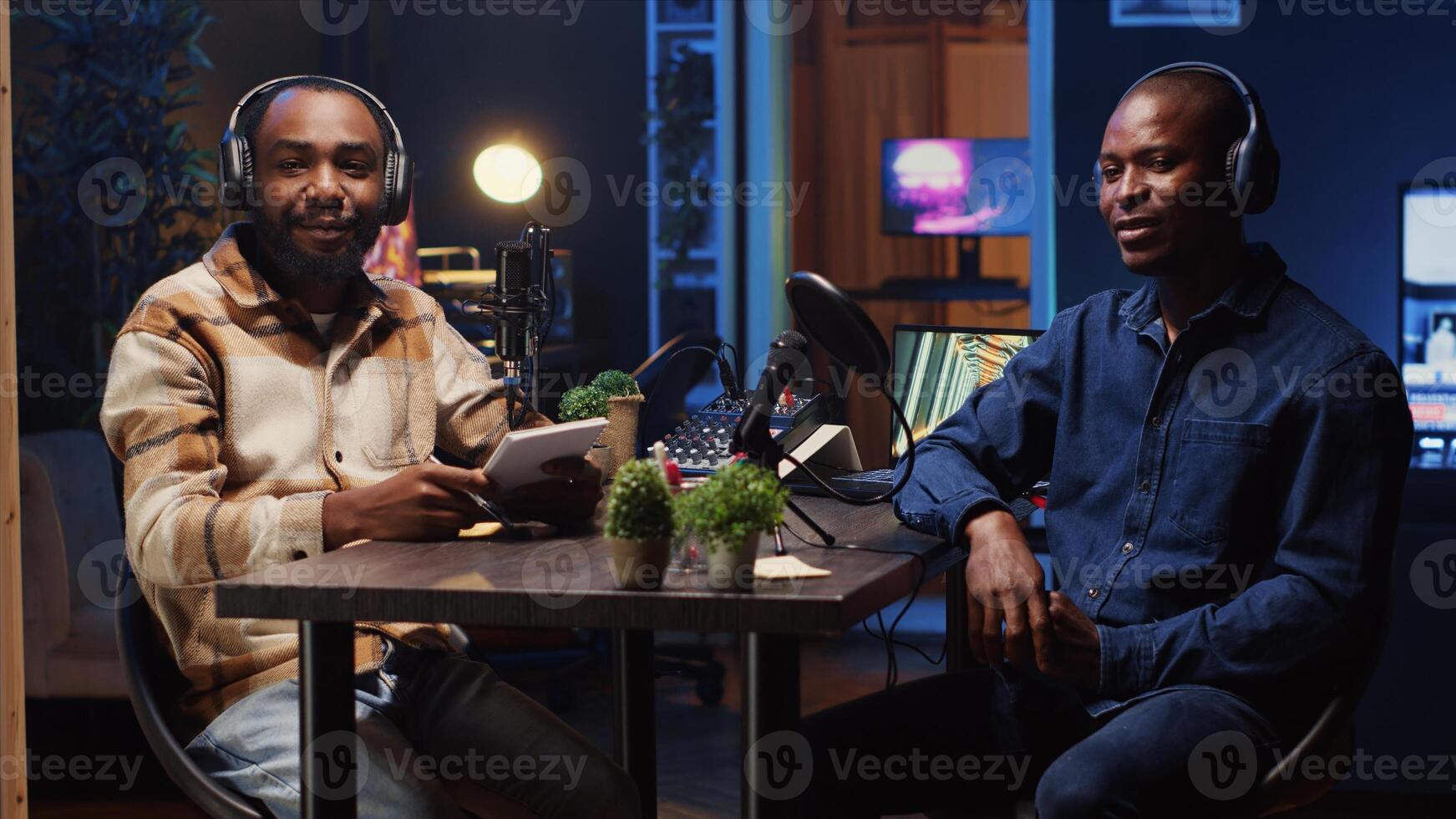Podcast journalist fist bumping guest, ready to start listening to his interesting story while viewers watch from home. Host greeting african american man invited in studio to share facts photo