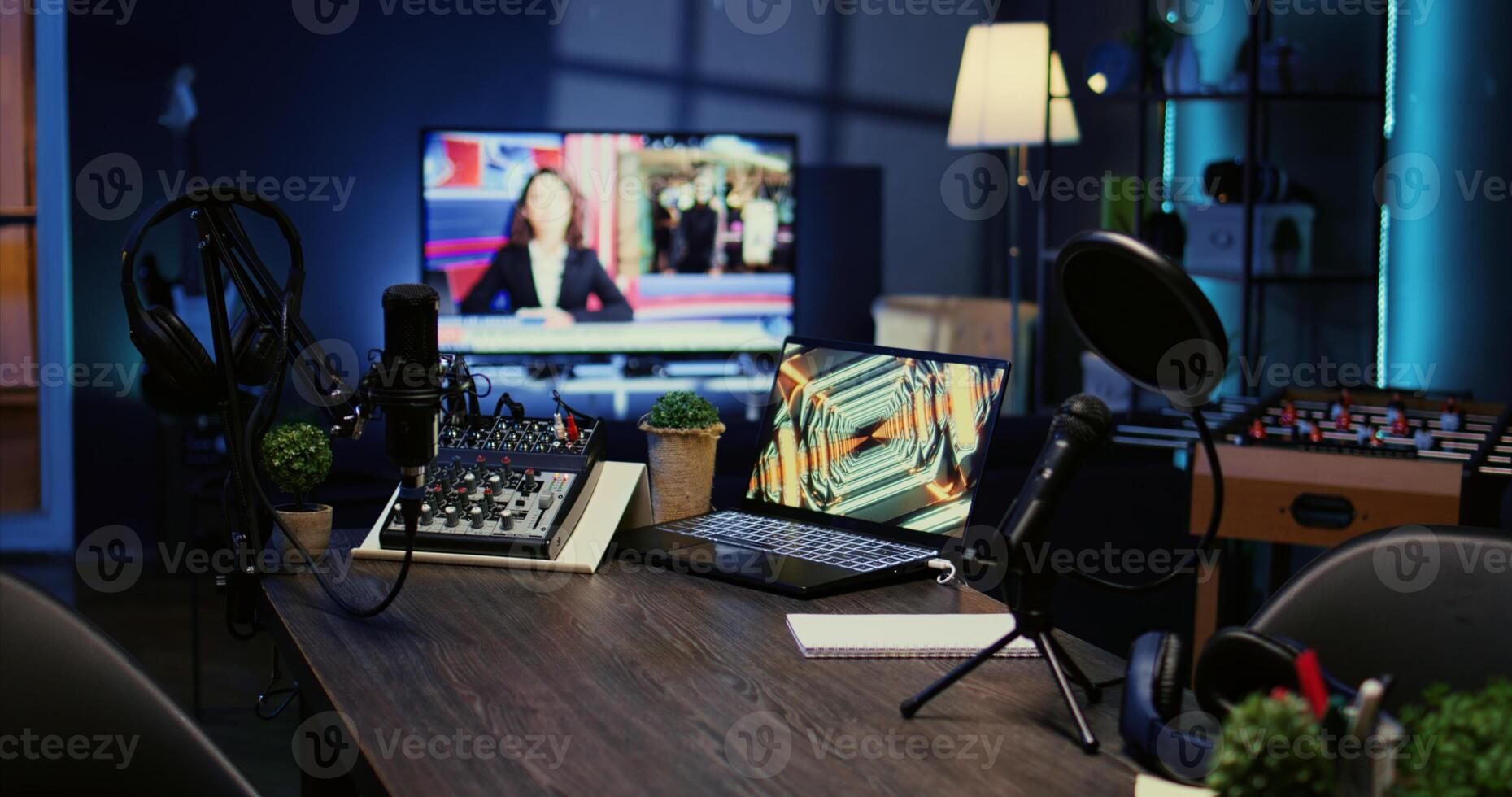 Jib down shot of empty desk in home production studio with podcast equipment technology recording sound for social media channel production. Live broadcasting space in dimly lit apartment photo