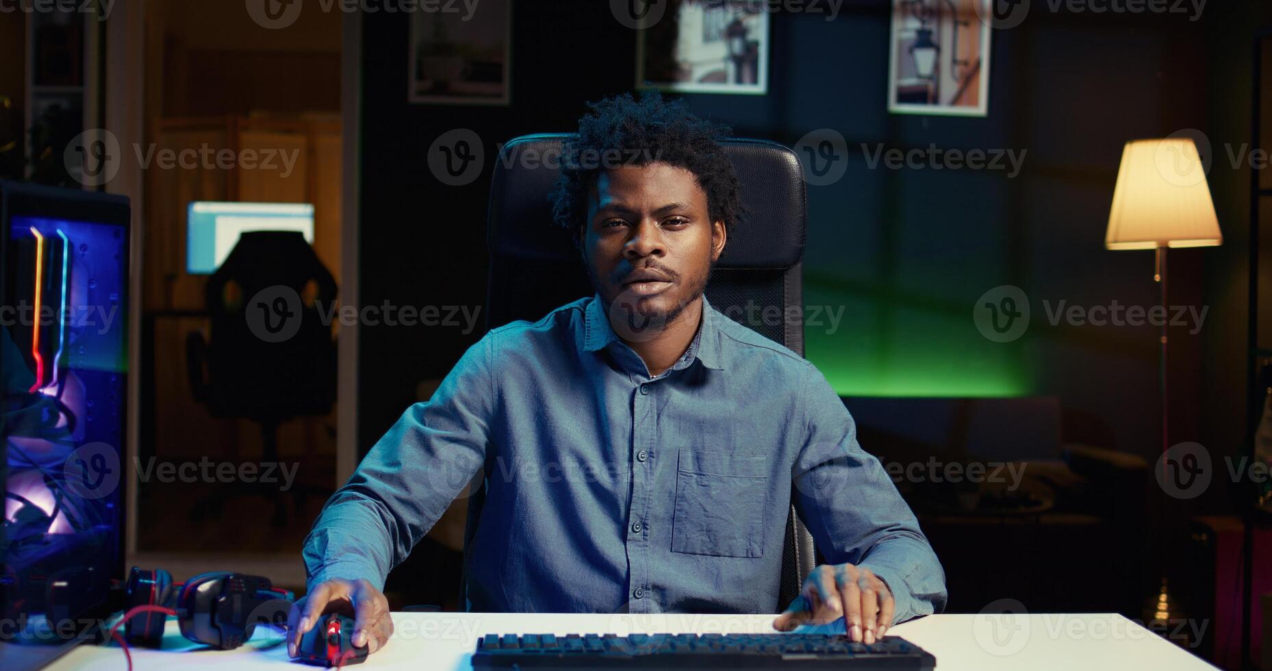 Man playing intense game on rgb lit computer desktop, spamming mouse and keyboard buttons to defeat enemies. Gamer in neon lit room focused on competitive videogame on PC photo