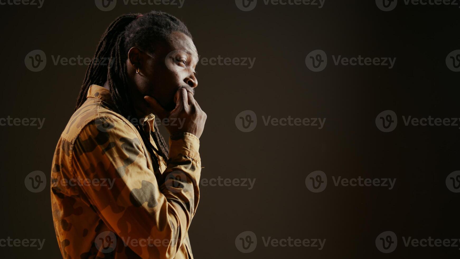 Confused male model being contemplative and reflective in studio, thinking about solution or answer to the question. Uncertain doubtful person being puzzled and sceptic, focused man. Handheld shot. photo