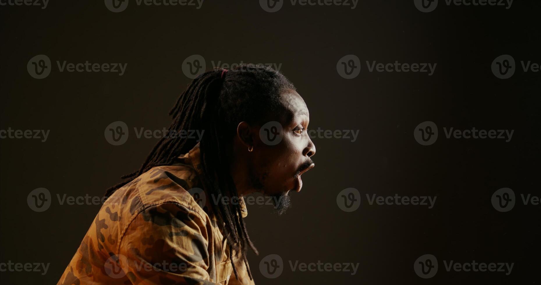 African american man cheers for someone on camera, supporting and encouraging people over black background. Person feeling confident and optimistic, celebrating success and win. Handheld shot. photo