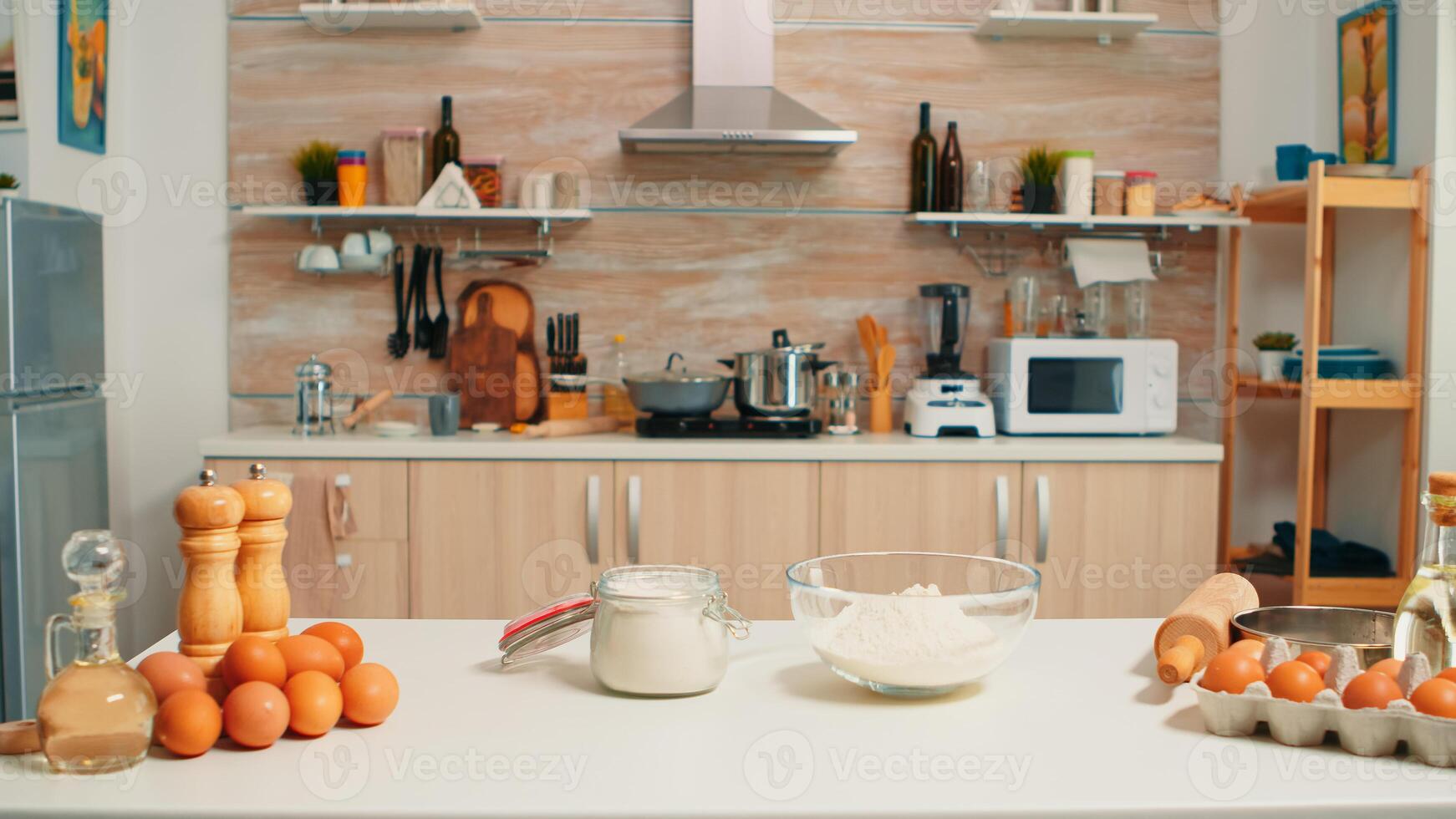 Pastelería ingredientes Listo para Cocinando en moderno cocina con nadie en él. moderno vacío comida habitación equipado con utensilios, Fresco huevos y trigo harina en vaso cuenco para hecho en casa pasteles y un pan foto