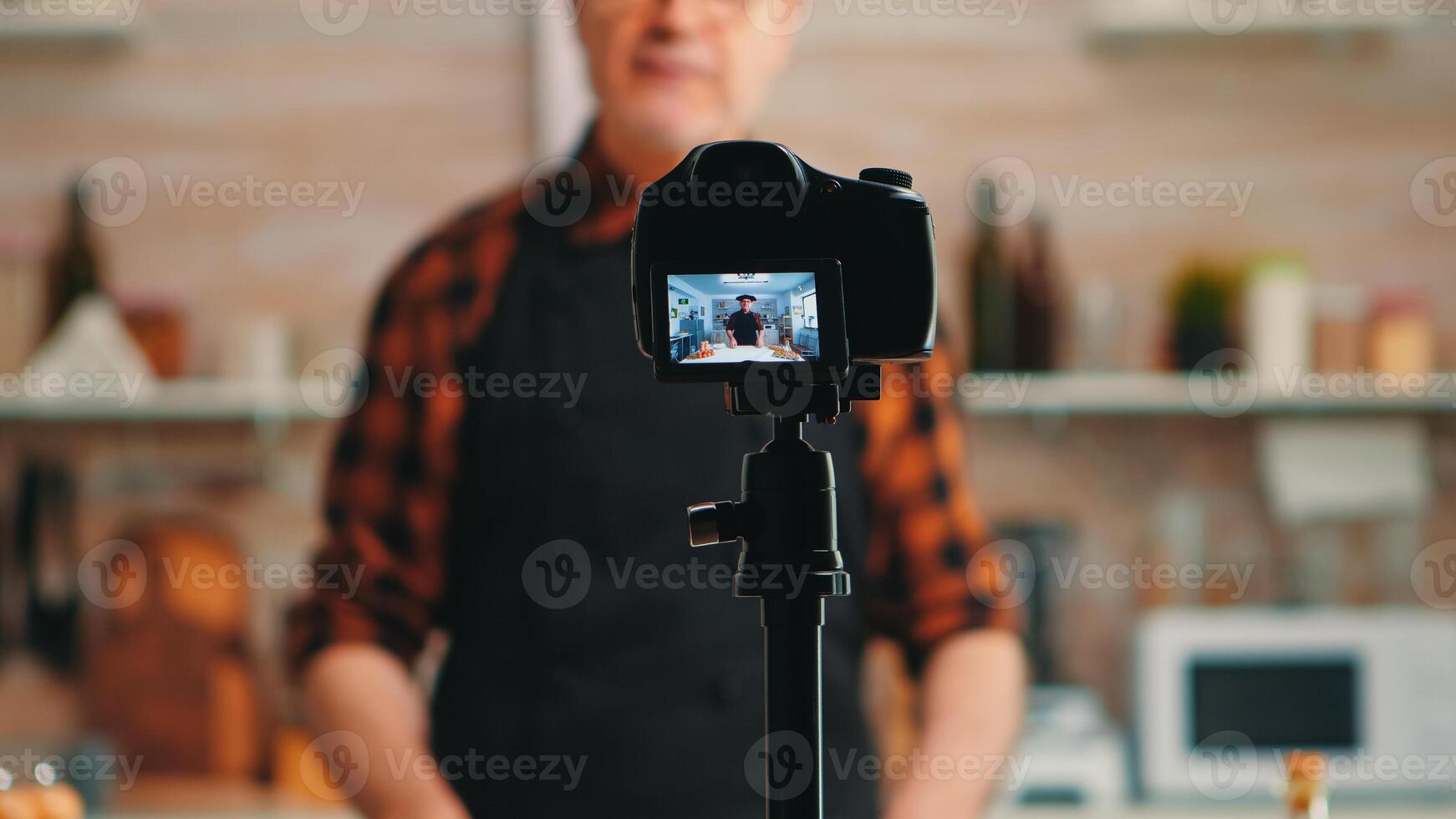 Baker presenting how using wheat flour while recording video tutorial. Retired blogger chef influencer using internet technology communicating, shooting blogging on social media with digital equipment photo