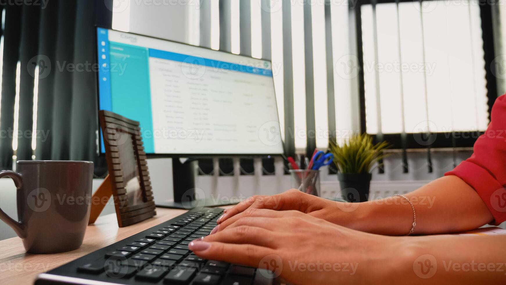 Woman fingers working on a computer keyboard in modern office room photo