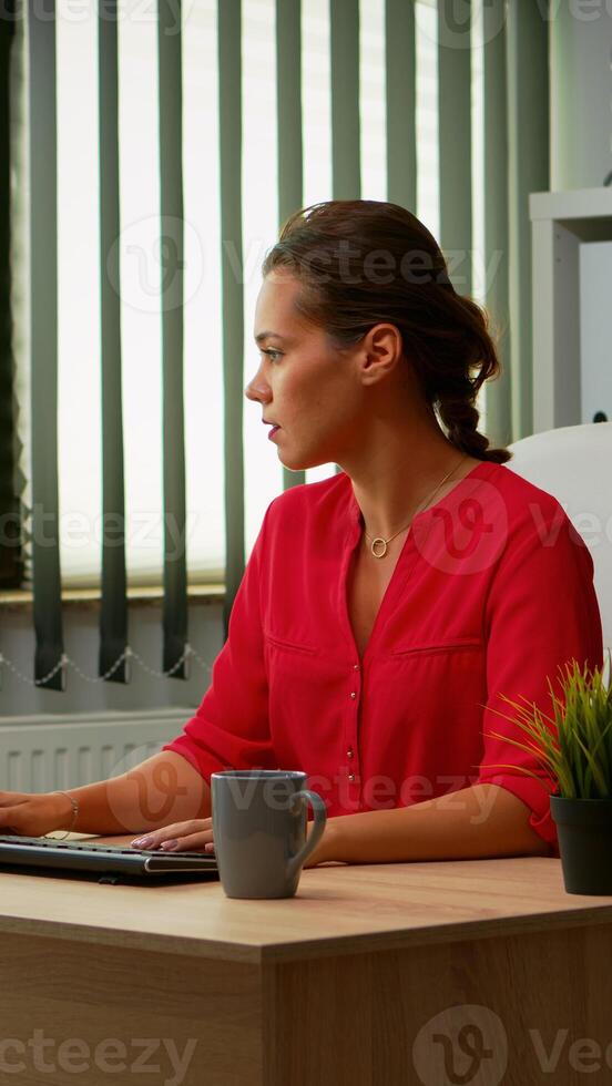 Busy employee typing on computer sitting on chair in modern office. Entrepreneur working in modern professional office, workplace in personal company typing on computer keyboard looking at desktop photo