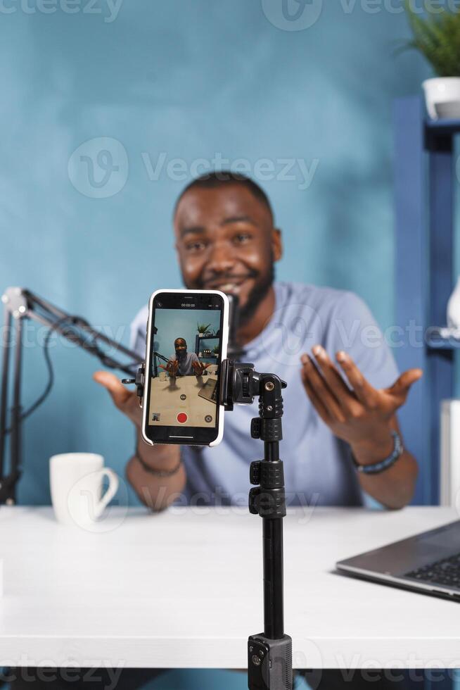 African american video blogger talking and recording blog content on smartphone close up. Vlogger speaking while creating web content for online vlog using mobile phone camera photo