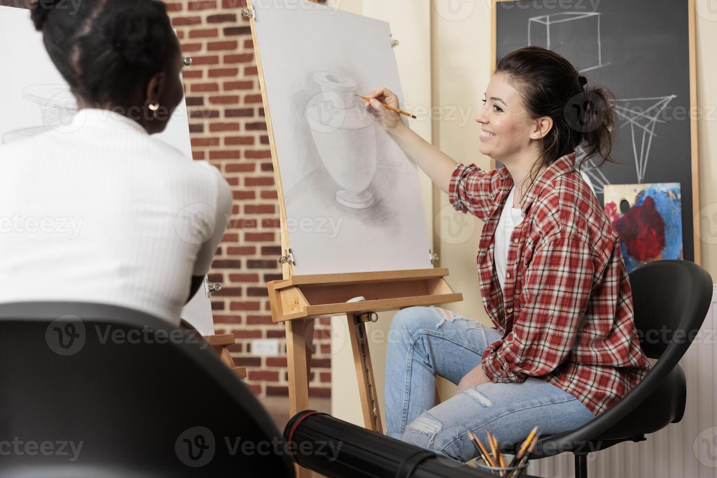 Two diverse girls best friends enjoying creative activities together, having enjoyable experience at art workshop, taking drawing class together. People enjoying creative hobby, learning something new photo