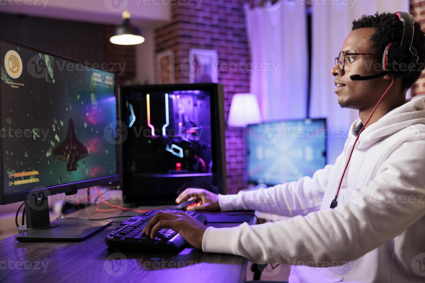 Gamer playing classic arcade space videogame, doing flying maneuvres through asteroid clusters. African american man using high tech gaming computer to solve levels in singleplayer game photo