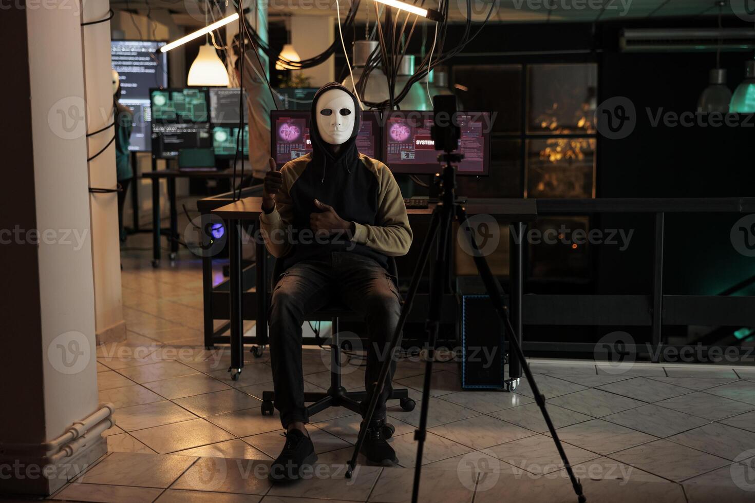 Hacking spy filming live ransomware video at night, breaking firewall encryption and stealing important information. Hacker with anonymous mask planting pc malware on database system. photo