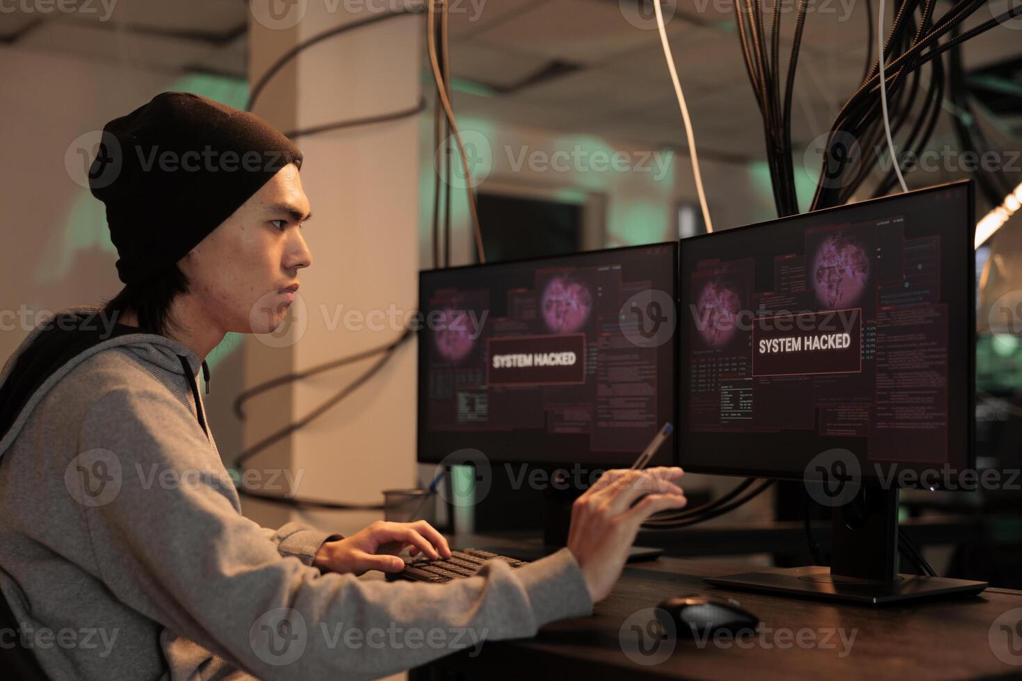 Asian hacker looking at firewall encryption to hack server, working with virus to steal personal information. Young thief causing security breach alert after breaking into computer system. photo
