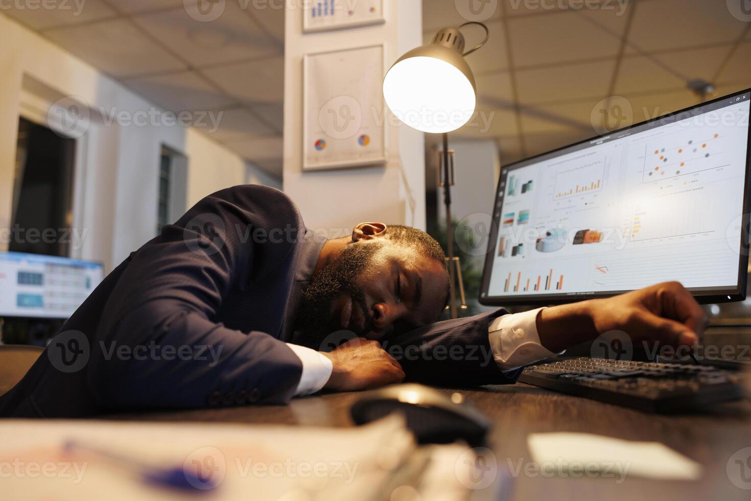 Exhausted tired executive manager suffering from sleepiness after working late at night in startup office. Drained african american worker with burnout syndrome sleeping at work. Business concept photo