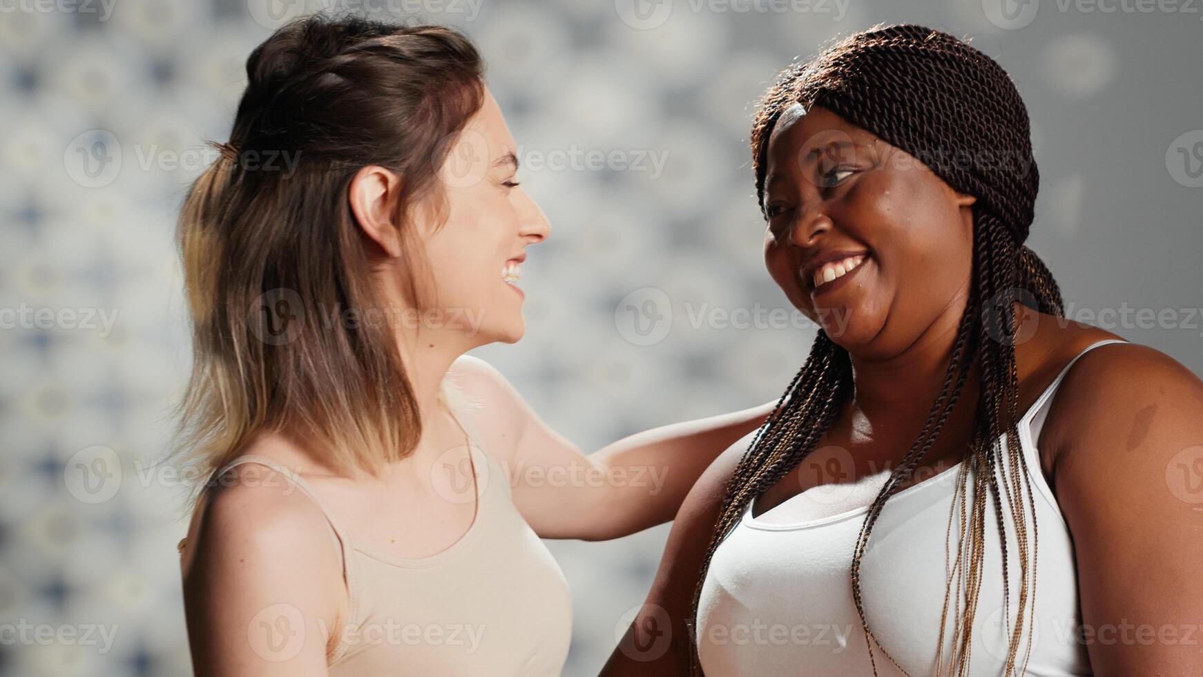 Diverse women feeling happy posing for skincare ad, models with different body types and skintones promoting self love and body acceptance. Beautiful girls laughing together in studio. photo