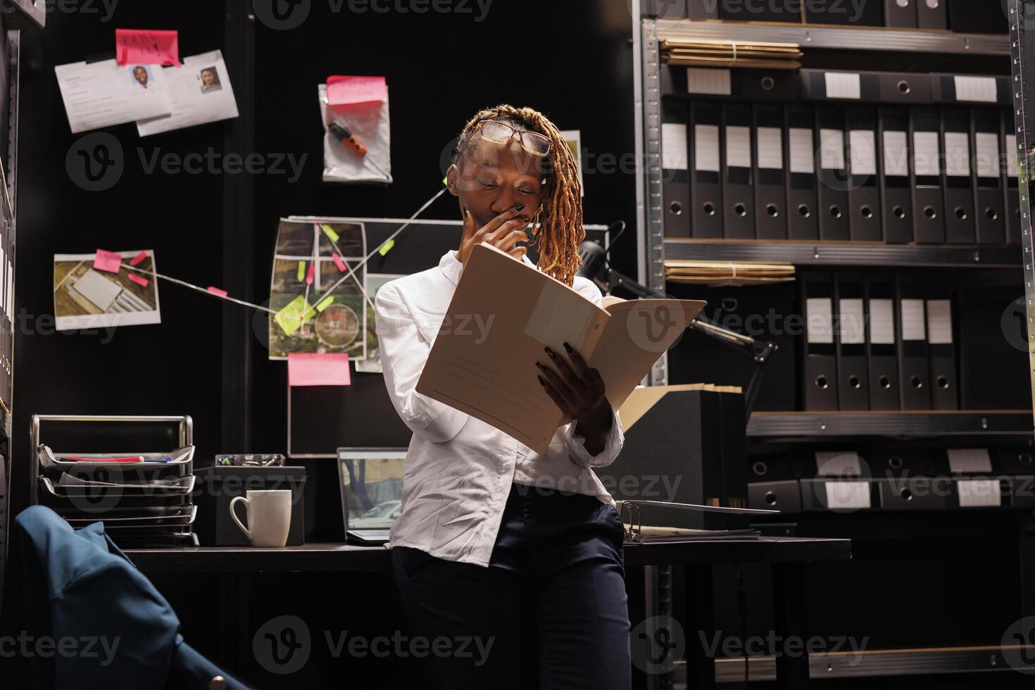 Law enforcement agency detective reading criminal investigation information file. African american woman investigator holding folder with crime case and analyzing csi expertise conclusion photo