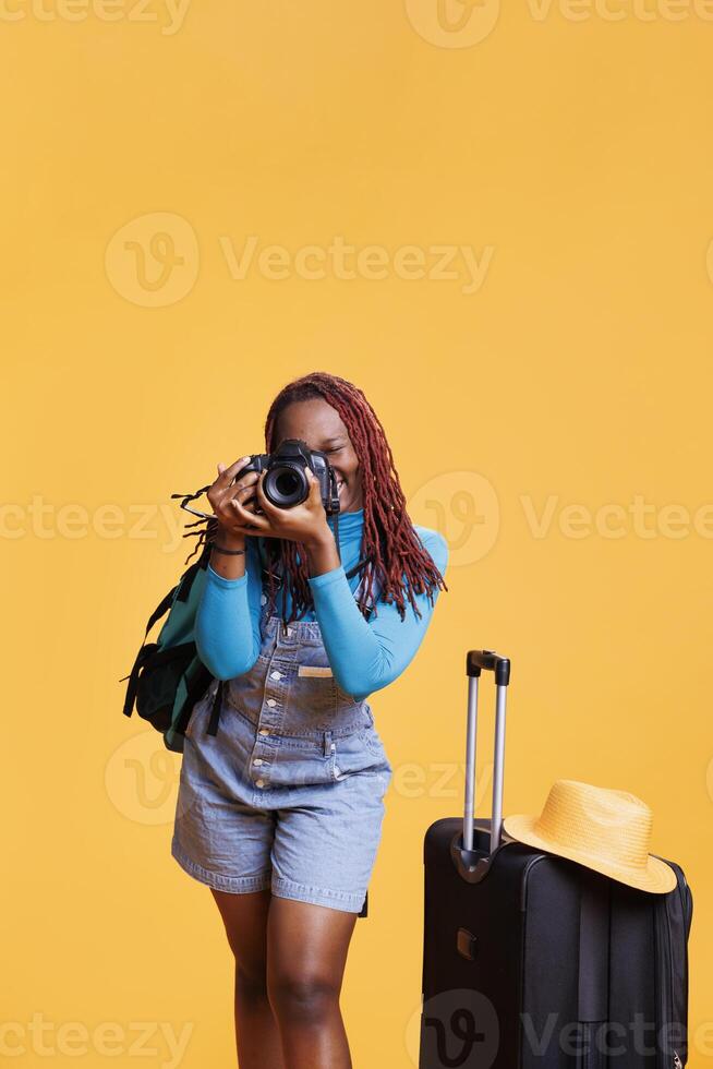 Traveller taking pictures with camera of buildings architecture and landscapes. Female model capturing images of scenic route and landmarks with luggage and suitcases, citybreak. photo