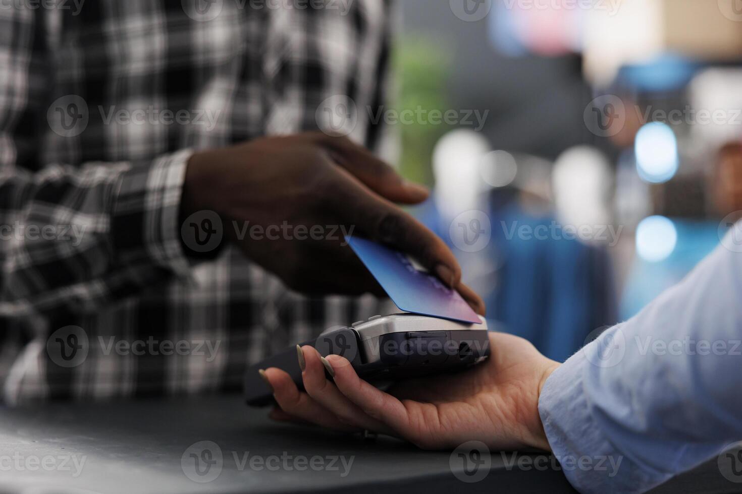 African american man shopper putting credit card on pos terminal paying formal for wear at counter desk in modern boutique, buying stylish clothes, fashionable accessories. Fashion concept. Close up photo